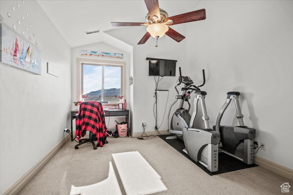 Exercise area featuring ceiling fan, lofted ceiling, and carpet flooring