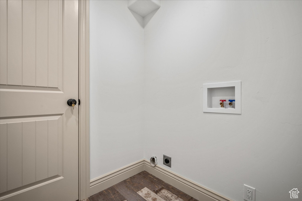 Clothes washing area with hookup for a washing machine, dark hardwood / wood-style floors, and hookup for an electric dryer