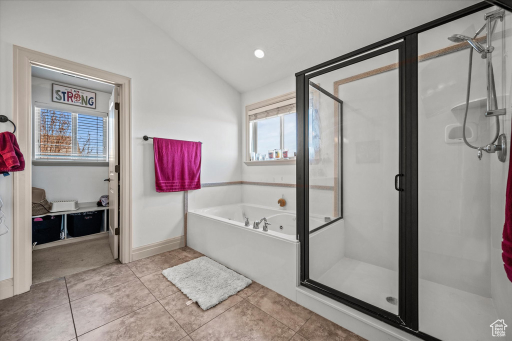 Bathroom with plenty of natural light, tile patterned floors, lofted ceiling, and separate shower and tub