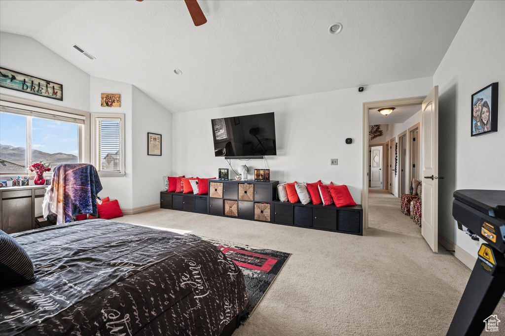 Bedroom featuring vaulted ceiling, light colored carpet, and ceiling fan