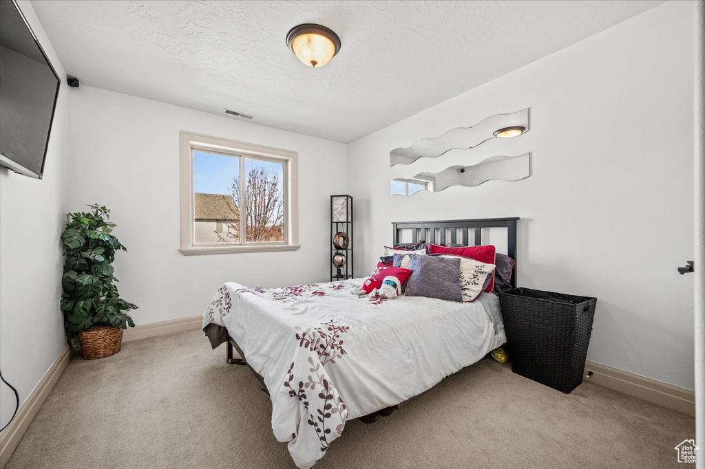 Carpeted bedroom featuring a textured ceiling