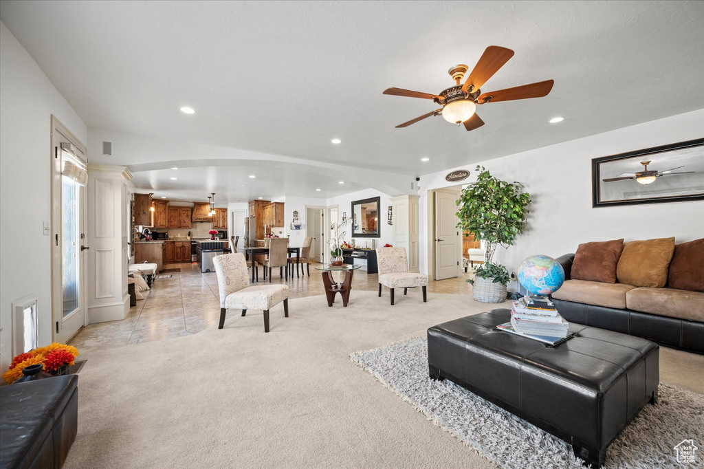 Carpeted living room featuring ceiling fan