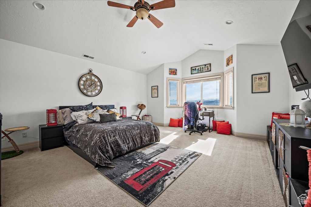 Carpeted bedroom with lofted ceiling and ceiling fan