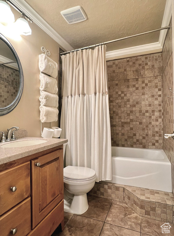 Full bathroom featuring shower / tub combo, ornamental molding, toilet, and a textured ceiling
