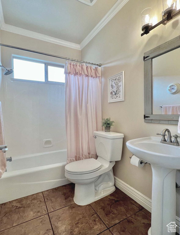 Full bathroom featuring toilet, sink, ornamental molding, shower / bath combo, and tile patterned flooring