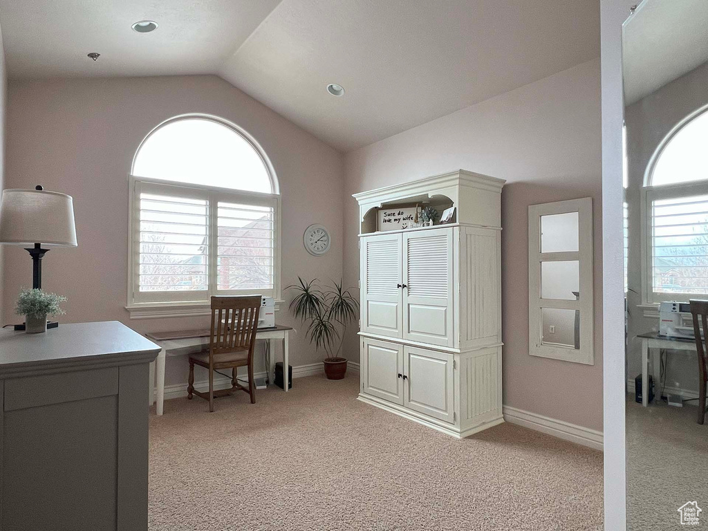 Home office with vaulted ceiling, light carpet, and a wealth of natural light