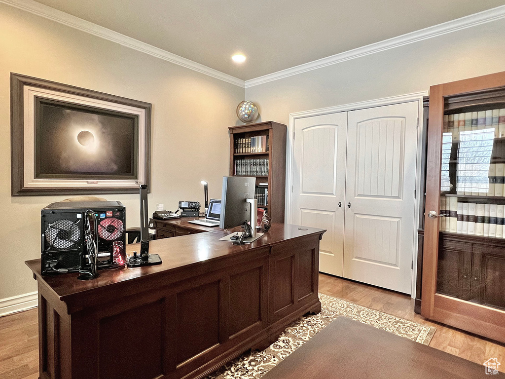 Home office with ornamental molding and light wood-type flooring