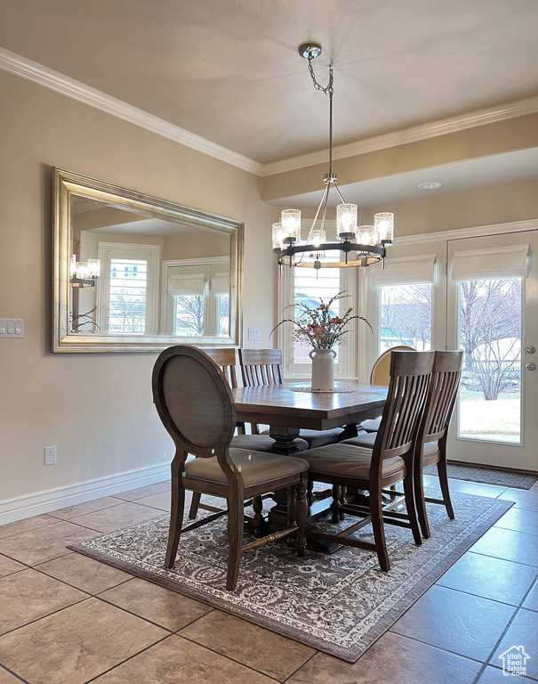 Tiled dining area with an inviting chandelier and crown molding