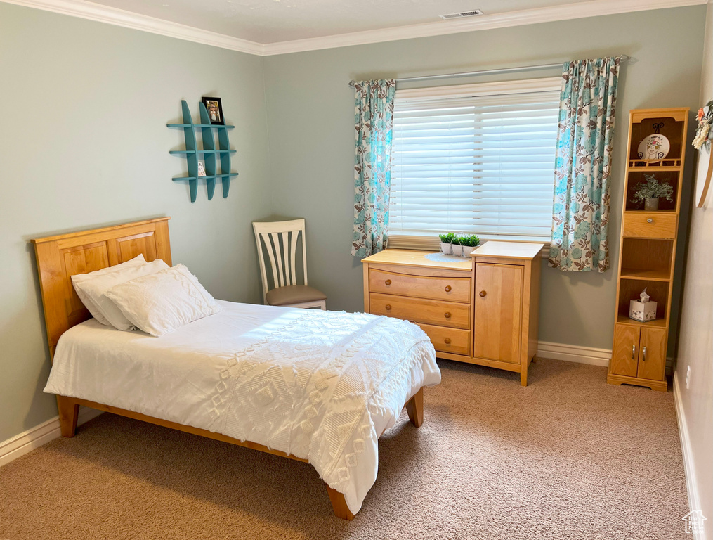 Carpeted bedroom with ornamental molding