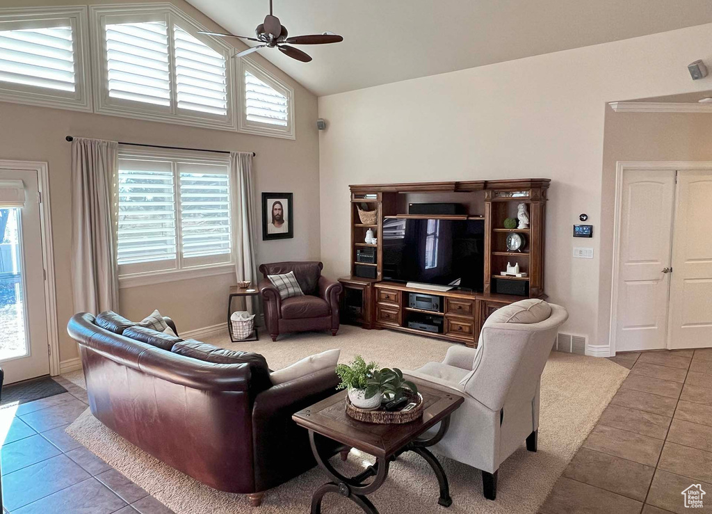 Tiled living room with high vaulted ceiling and ceiling fan
