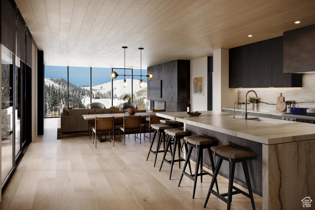 Kitchen with decorative light fixtures, wood ceiling, floor to ceiling windows, a mountain view, and light hardwood / wood-style flooring