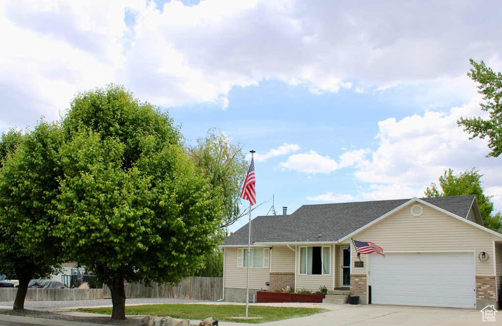 View of front of home featuring brick siding, a garage, driveway, and a shingled roof