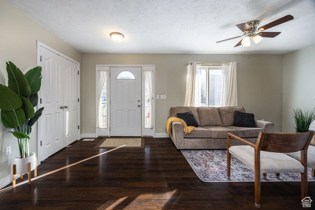 Foyer entrance with ceiling fan, dark hardwood / wood-style floors, and a textured ceiling