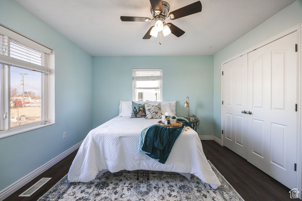 Bedroom featuring dark wood-type flooring, a closet, and ceiling fan