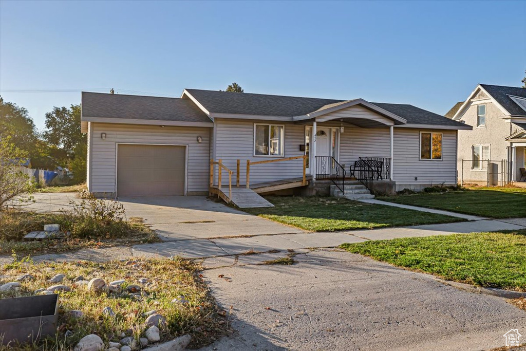 View of front of house with a garage and a front lawn