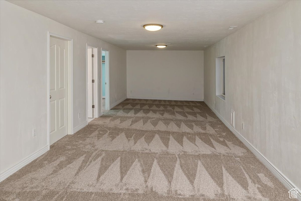 Empty room featuring light colored carpet