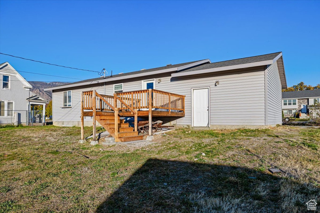 Back of property featuring a yard and a deck