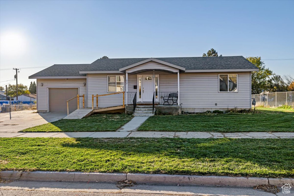 View of front facade with a garage, a front yard, and covered porch