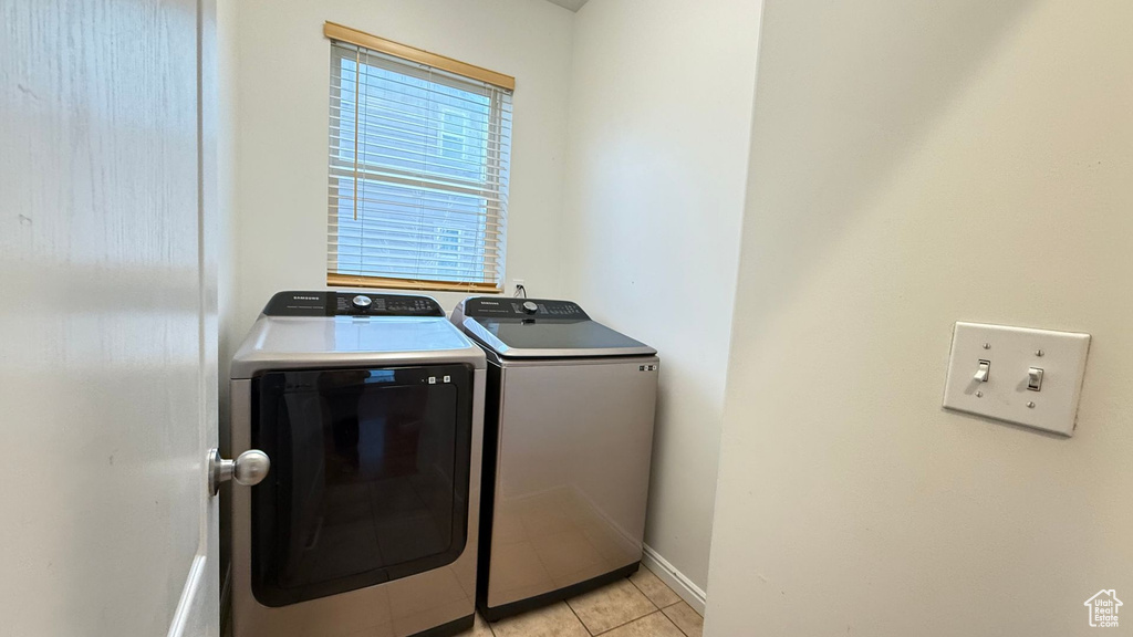 Laundry room with washer and dryer and light tile patterned floors