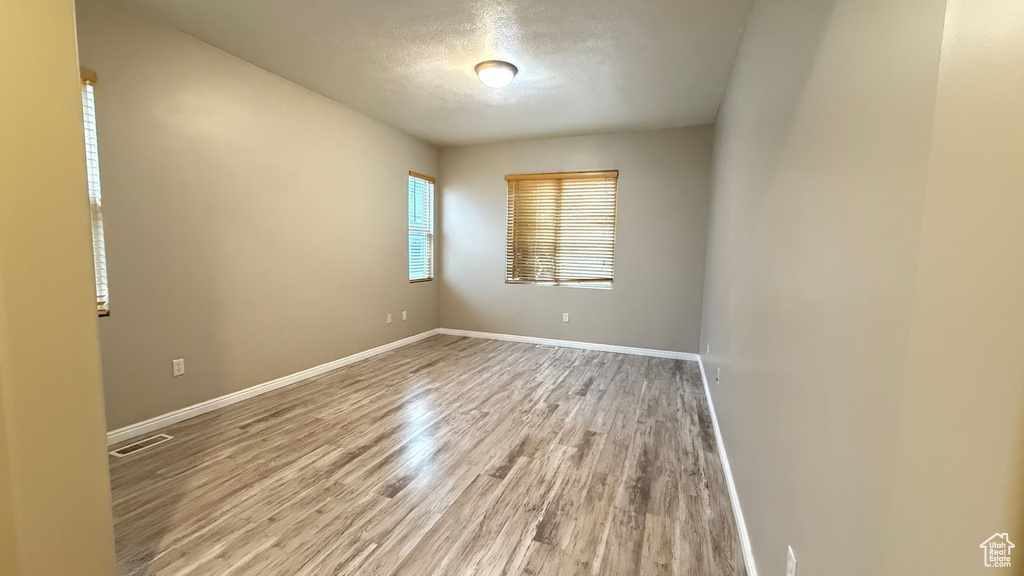 Spare room featuring hardwood / wood-style floors and a textured ceiling