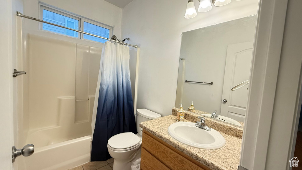 Full bathroom with vanity, tile patterned floors, toilet, and shower / bath combo