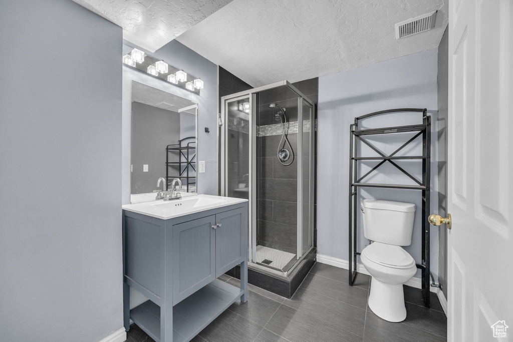 Bathroom featuring visible vents, baseboards, toilet, and a shower stall