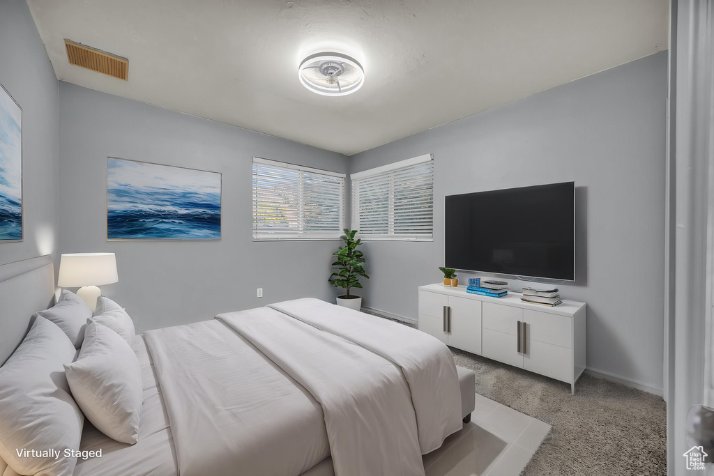 Bedroom featuring light colored carpet, baseboards, and visible vents