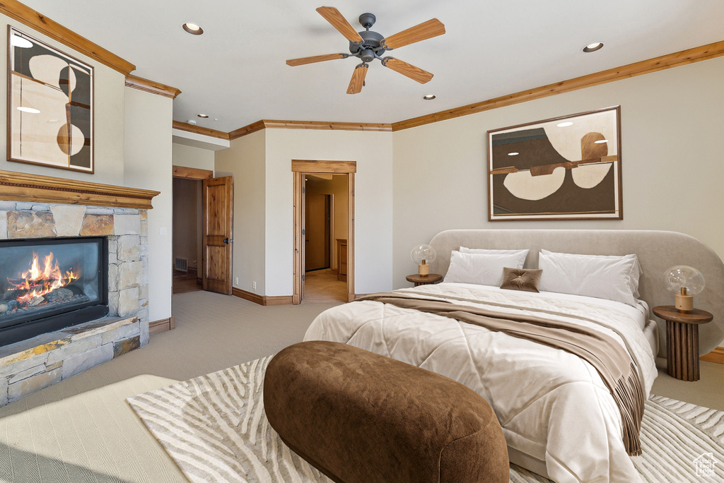 Carpeted bedroom with crown molding, a stone fireplace, recessed lighting, and a ceiling fan