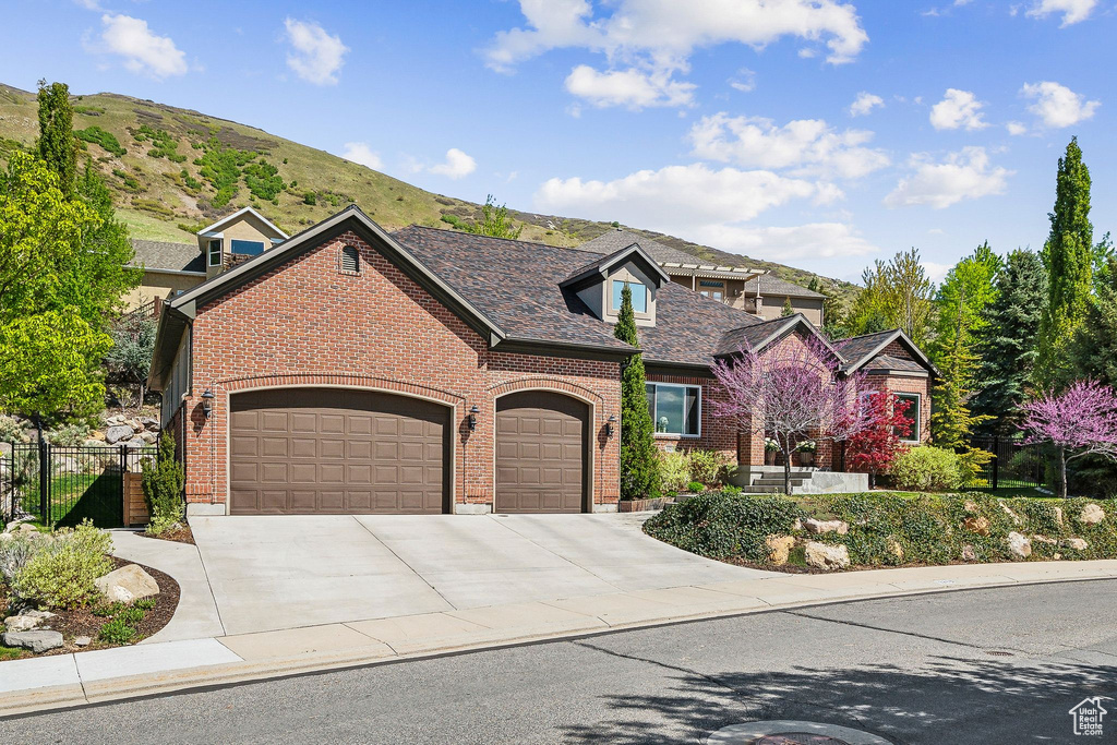View of front of home featuring fence, an attached garage, concrete driveway, and brick siding