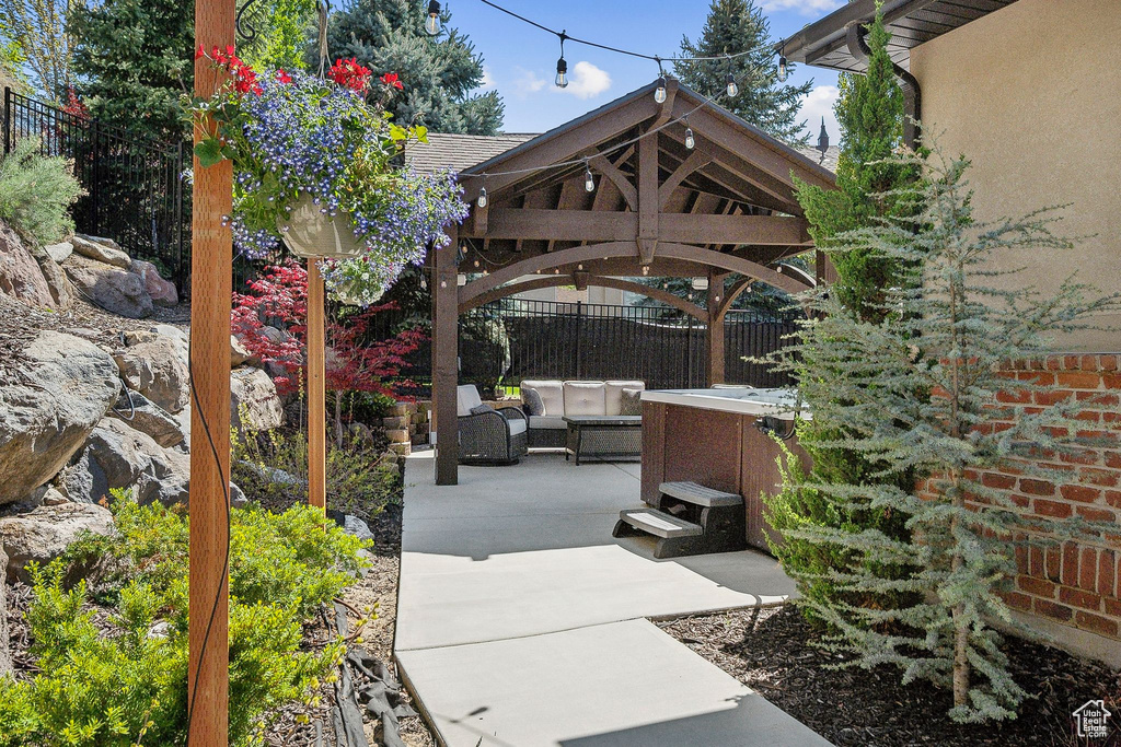 View of patio with fence, a gazebo, and outdoor lounge area