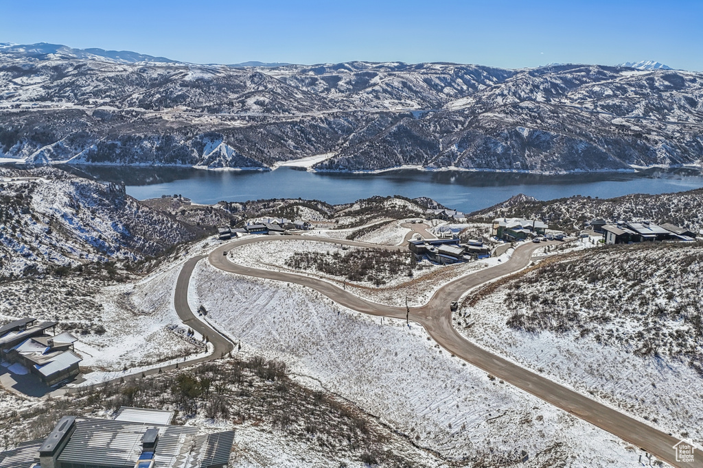 Snowy aerial view featuring a water and mountain view