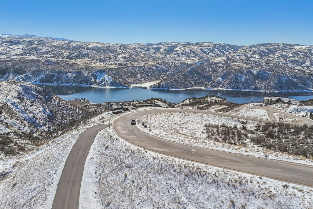 Snowy aerial view featuring a water and mountain view