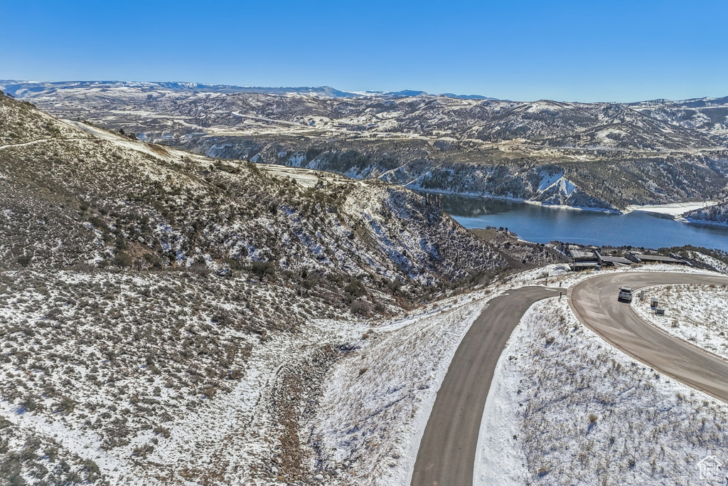 Snowy aerial view featuring a water and mountain view