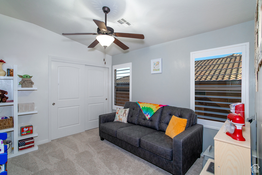 Carpeted living room with ceiling fan