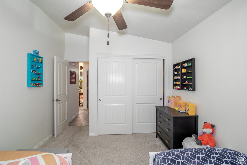 Carpeted bedroom with vaulted ceiling, a closet, and ceiling fan