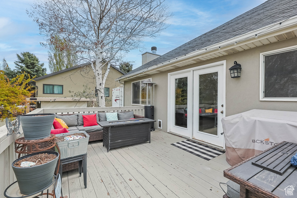 Deck with an outdoor living space with a fire pit