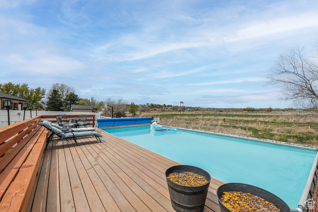 View of swimming pool featuring a covered pool and a deck