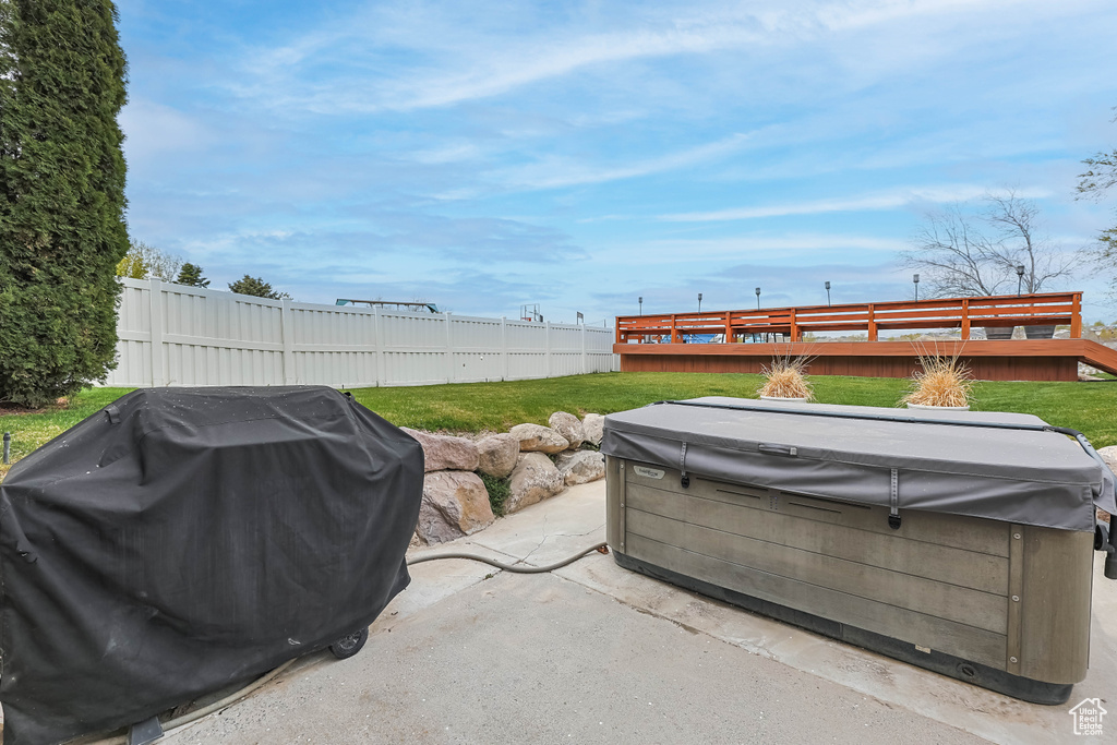 View of patio with a fenced backyard, a hot tub, and area for grilling