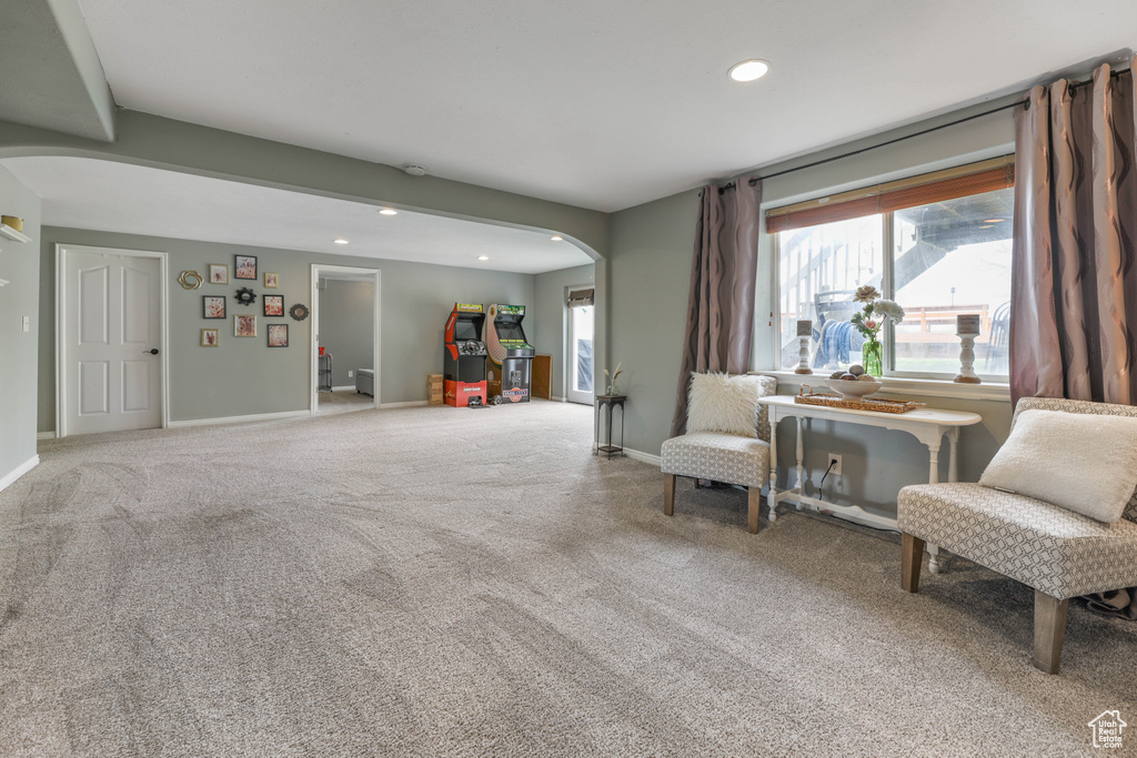 Sitting room with arched walkways, carpet flooring, baseboards, and recessed lighting