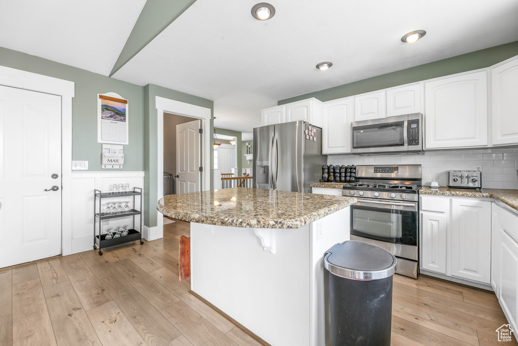 Kitchen featuring white cabinets, stainless steel appliances, and a kitchen island
