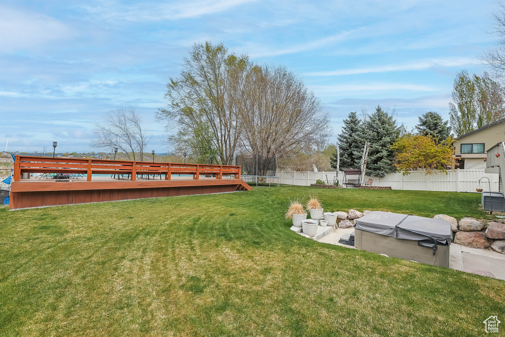 View of yard featuring a fenced backyard, a wooden deck, and a hot tub