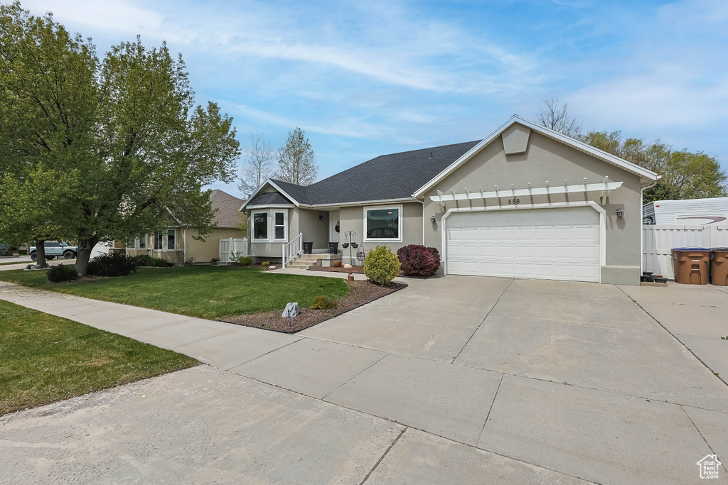 Single story home with roof with shingles, driveway, a garage, a front yard, and stucco siding