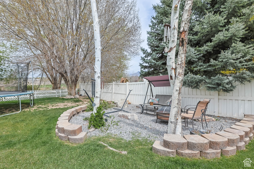 View of yard with a patio, a fenced backyard, and a trampoline