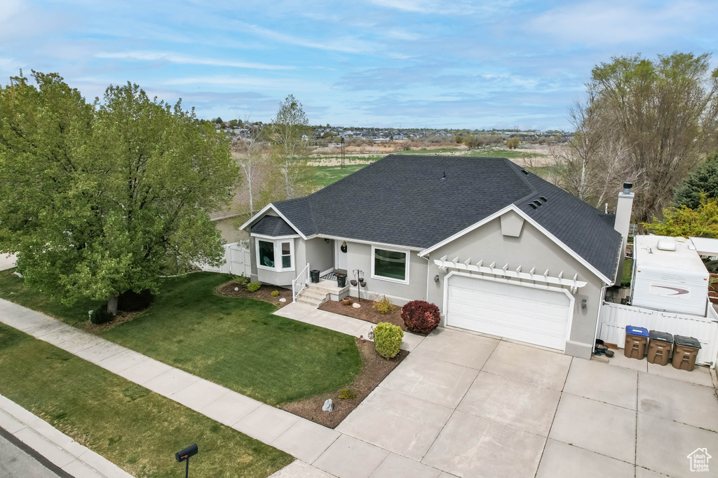 Single story home with fence, a front lawn, concrete driveway, an attached garage, and roof with shingles