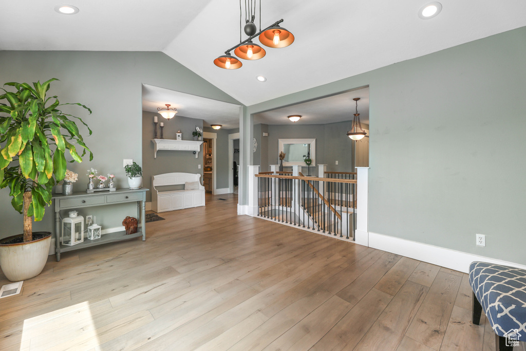 Interior space featuring baseboards, recessed lighting, visible vents, lofted ceiling, and wood finished floors