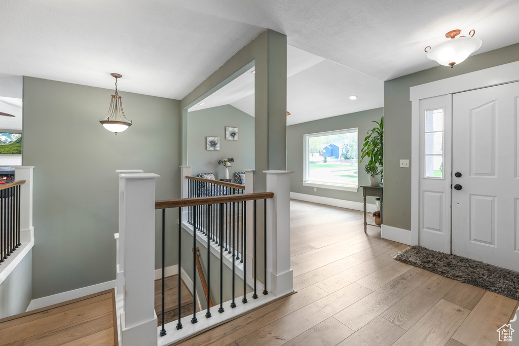 Entrance foyer featuring wood finished floors, lofted ceiling, and baseboards
