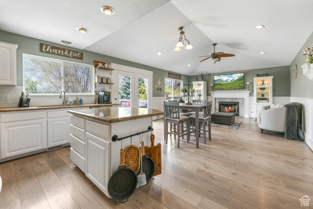 Kitchen with ceiling fan, white cabinetry, a sink, and plenty of natural light