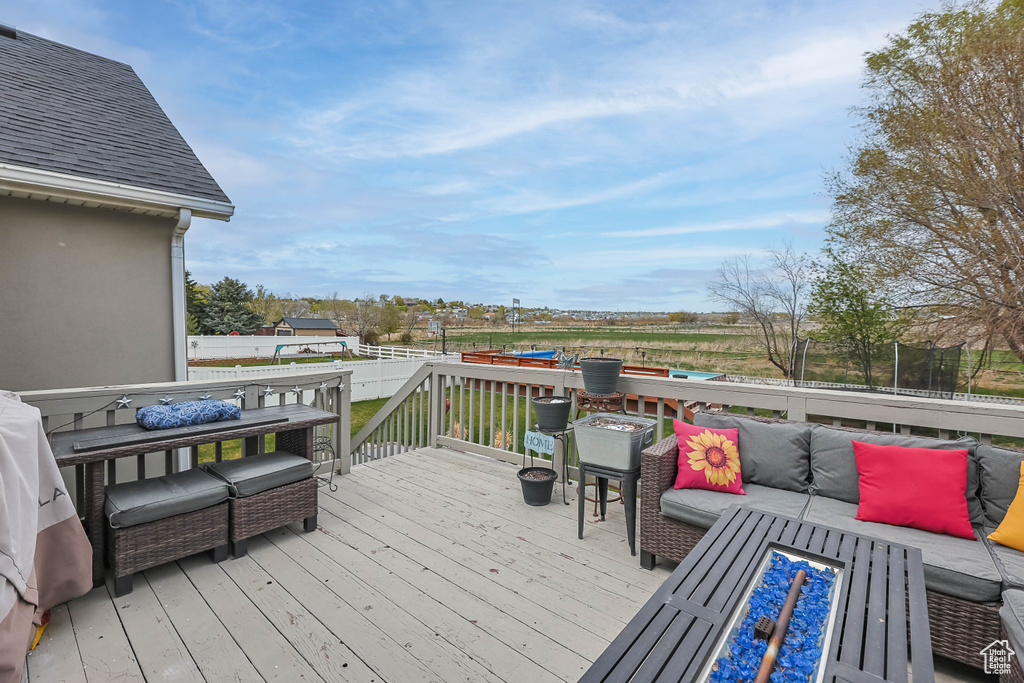 Wooden terrace with an outdoor hangout area and a trampoline