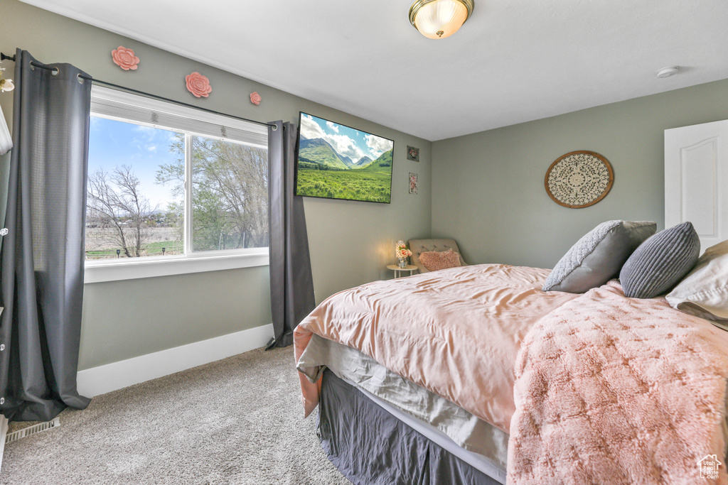 Bedroom featuring carpet and baseboards