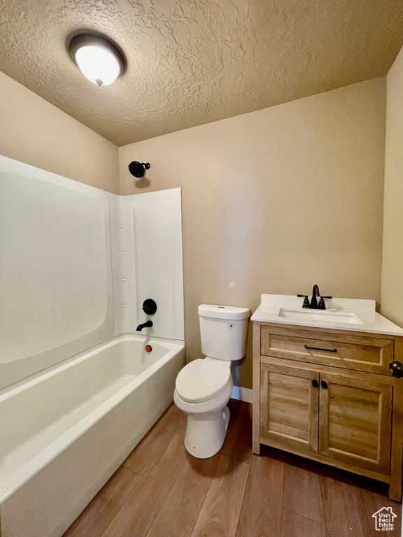 Full bathroom featuring washtub / shower combination, vanity, toilet, and hardwood / wood-style floors